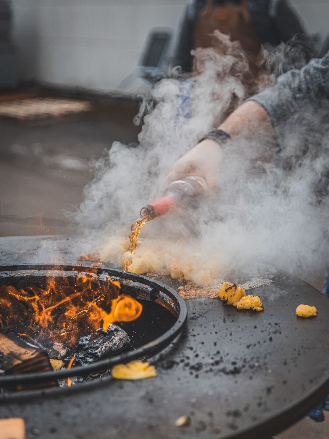 Die Ananas wird mit Rum getränkt, anschließend gibt es noch einen Schuss Alkohol ins Feuer