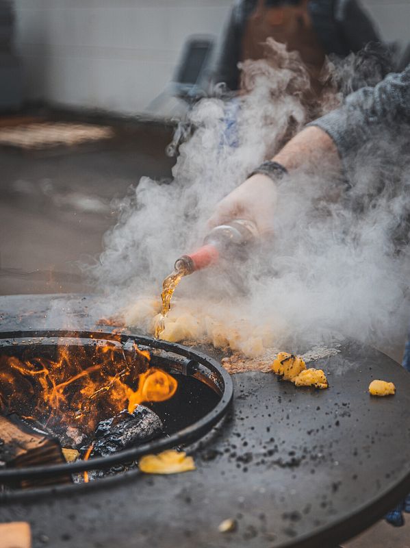 Die Ananas wird mit Rum getränkt, anschließend gibt es noch einen Schuss Alkohol ins Feuer