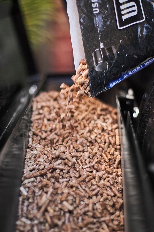 Die Hartholzpellets von Weber werden in den Pelletbehälter des Smokefires nachgefüllt