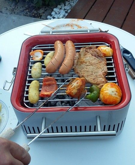 Everdure Cube mit vollem Grillrost auf einem Gartentisch