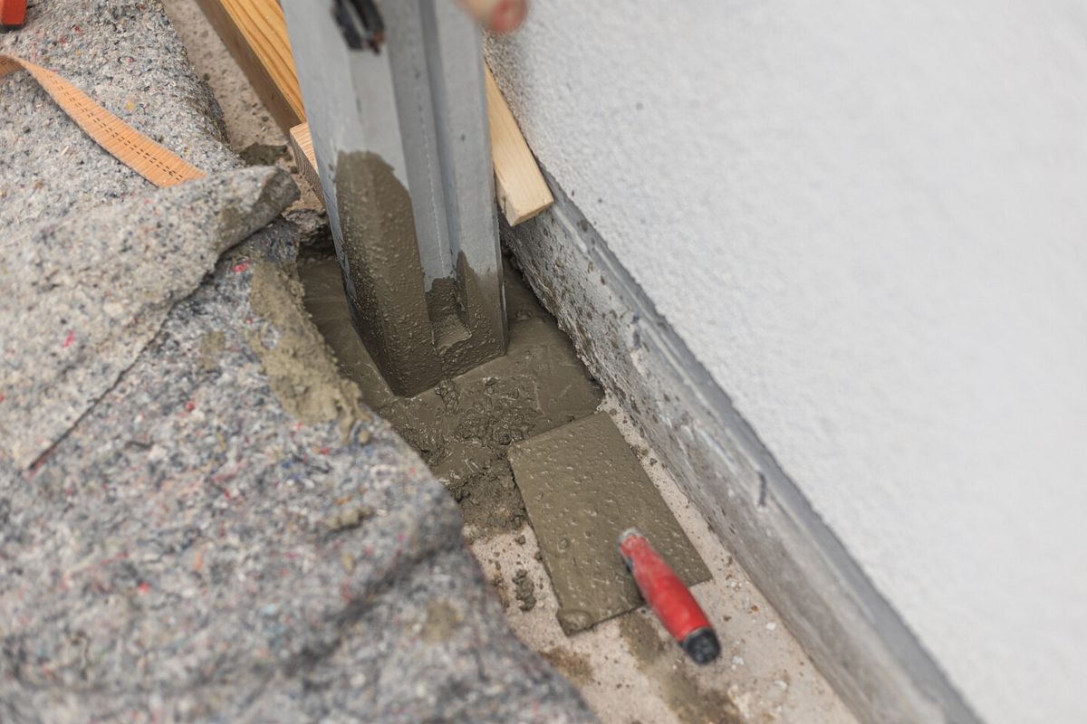 Die Betonmasse wird um die Pfosten herum ausgegossen