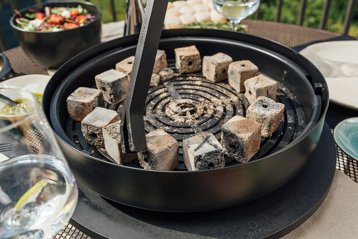 Der Ofyr Tischgrill wird mit Briketts aufgeheizt
