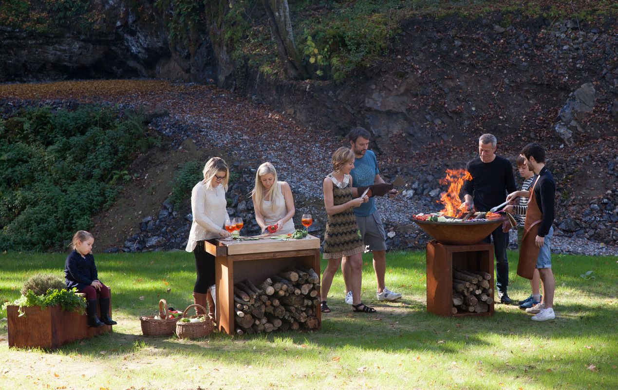 Eine Grillparty im Grünen gelingt mit Kocheinheit und Zubehör von Ofyr wie dem Butcher Block und der Garden Bench besonders gut